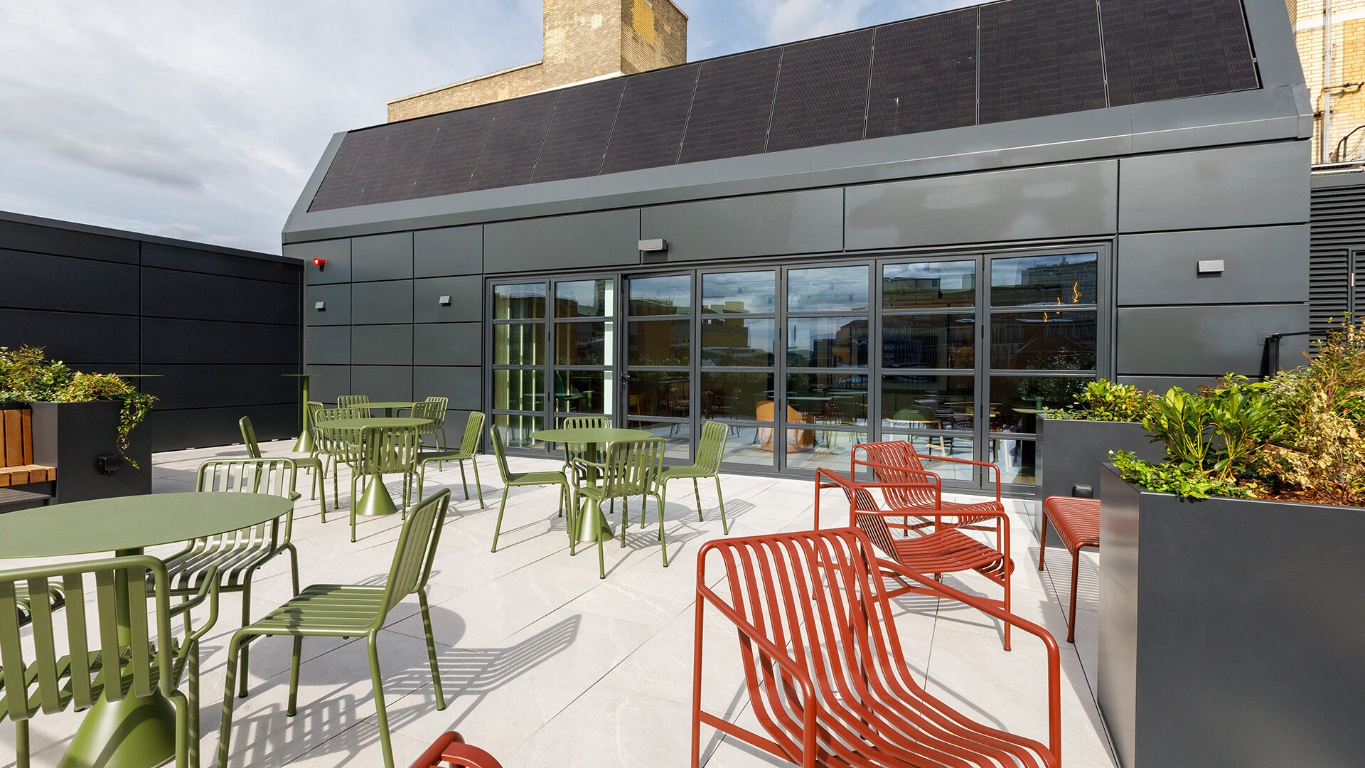 Rooftop terrace at 35 Newhall with outdoor seating, planting and solar panels above the Sky Lounge